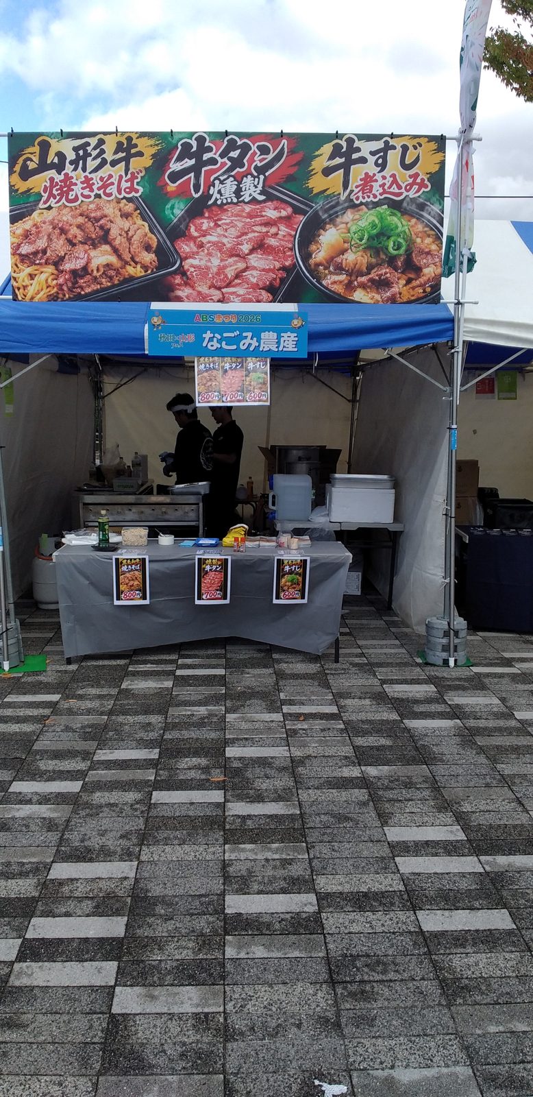 秋田のイベントに出店したなごみ農産のブース。山形牛焼きそば・牛タン燻製・牛すじ煮込みの看板
